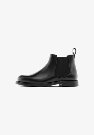 Black leather Chelsea boot with elastic side panels, a rounded toe, and a pull tab at the back. Smooth finish and sturdy rubber sole.