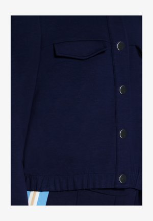Marineblaue, kurz geschnittene Jacke aus weichem Stoff mit Druckknöpfen, einer Vorderseite mit Tasche und einem gerafften Saum.