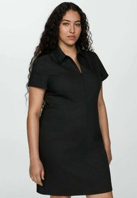 Rochie neagră cu mâneci scurte și guler, prezentând o siluetă mulată și o textură netedă. Fără modele sau accente vizibile.