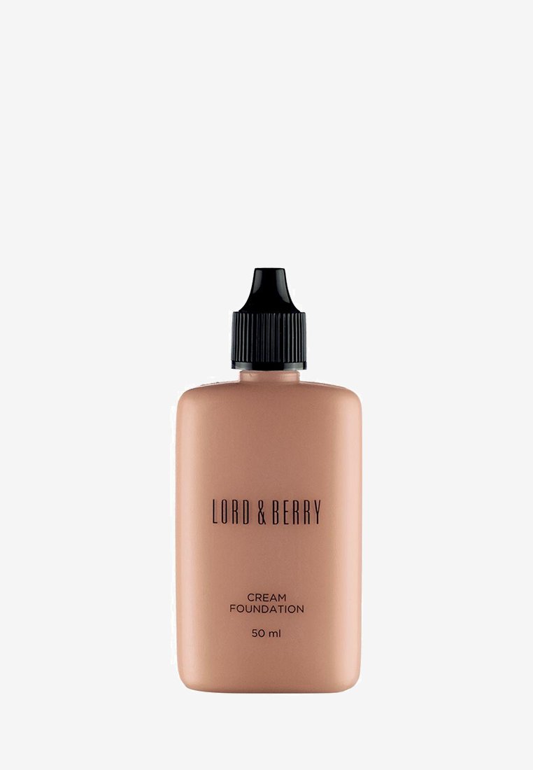 Krämfoundation i en 50 ml matt persikofärgad flaska, med ett svart ribbat lock och fet svart text på framsidan.
