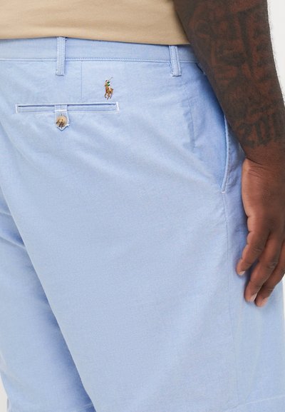 Shorts bleu clair en tissu doux avec une poche arrière dotée d'une fermeture à bouton et d'un petit logo brodé d'un joueur de polo.