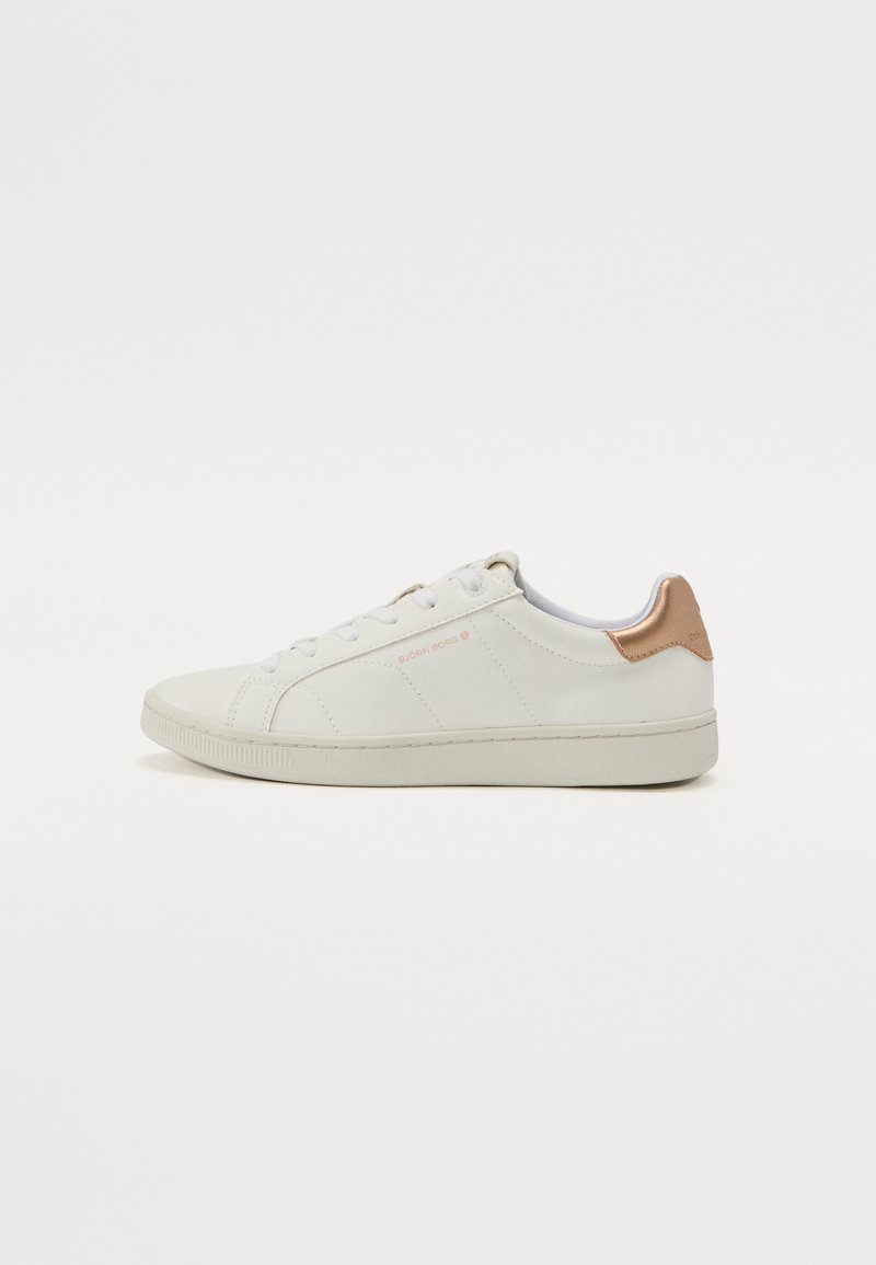 Hvit lær sneakers med tan lær detaljer på hælen, rund tå og flate gummisåler. Har snøring med diskret søm.