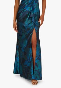 Dlouhá, upnutá šaty z tmavě modrého saténu s zelenými květinovými vzory. Obsahuje boční rozparek a zavinovací detail v pase.