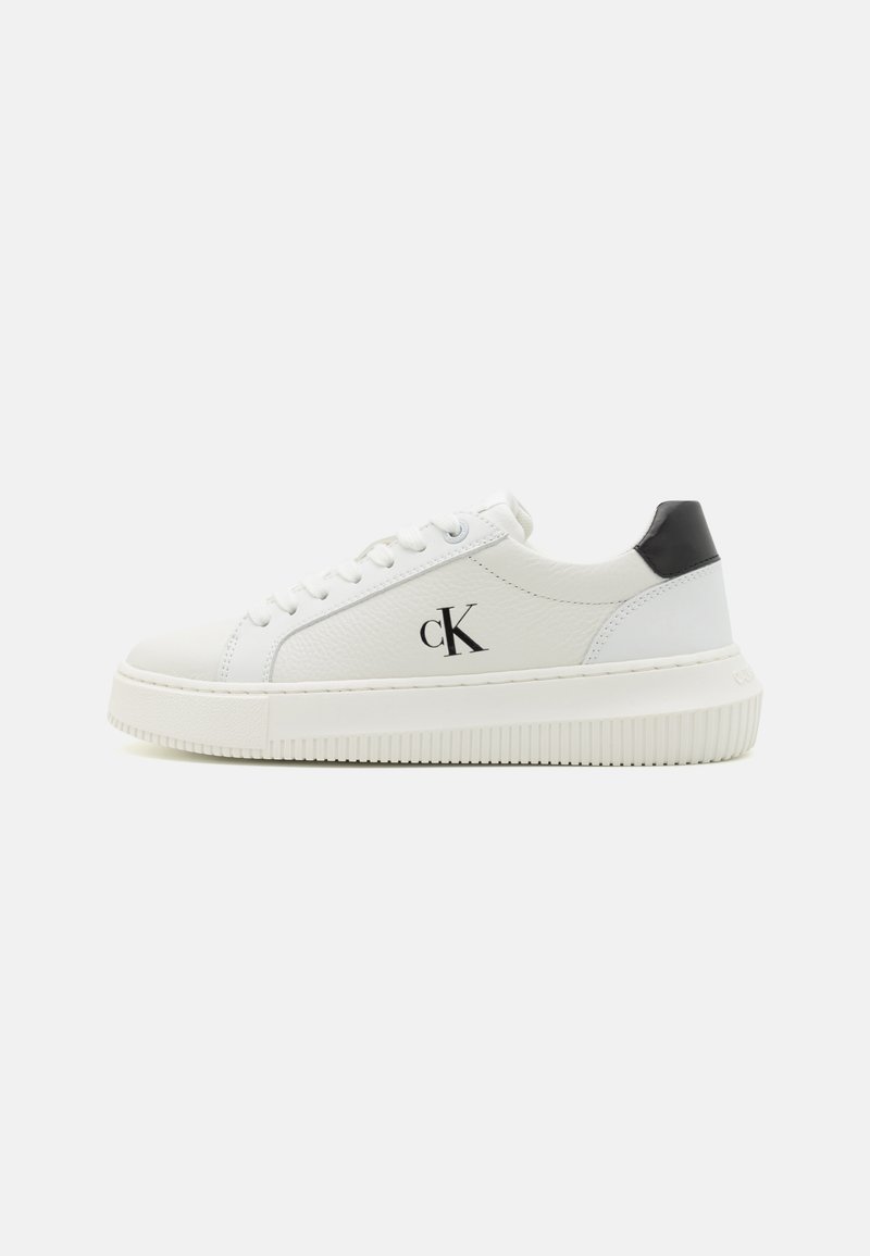 Weiße Lederturnschuhe mit einer schwarzen Fersenblende, schnürbarem Vorderteil, strukturiertem Finish und einer erhöhten weißen Gummisohle. Mit einem kleinen schwarzen Logo.