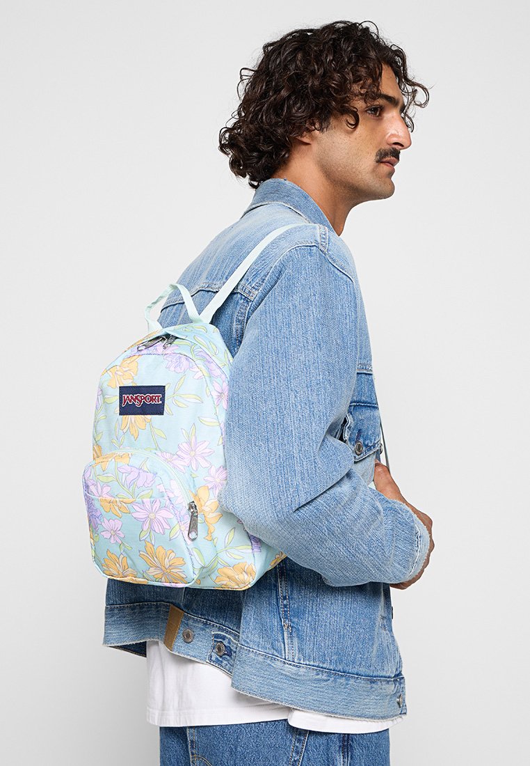 Zaino con motivo floreale su sfondo blu chiaro, con spallacci regolabili, tasche con zipper e un'etichetta con logo. Realizzato in tessuto resistente.