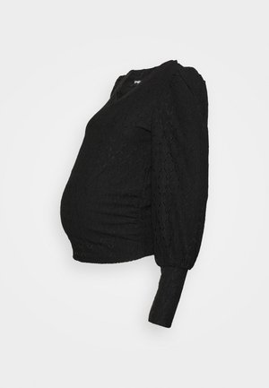 Top de maternidade preto com tecido texturizado, mangas curtas em balão e detalhe franzido na lateral para uma silhueta ajustada.