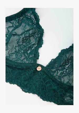 Błękitny koronkowy biustonosz z misternym kwiatowym wzorem, falbaniastymi krawędziami oraz małą metalową metką. Miękka tkanina o delikatnej fakturze.