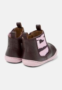 Chaussures pour bébés en cuir brun foncé avec des côtés élastiques à motifs roses et noirs et des semelles rose clair, présentées de l'arrière et en vue angulaire.