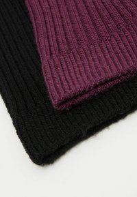 Zwei gestrickte Schals in Schwarz und Dunkelviolett mit einer gerippten Textur. Jeder hat ein weiches, warmes Aussehen und ist ordentlich gestapelt.