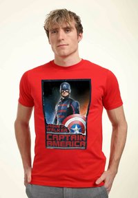Czerwona bawełniana koszulka z nadrukiem przedstawiającym postać w kostiumie z tarczą, poniżej tekst "JOHN F. WALKER" oraz "CAPTAIN AMERICA."