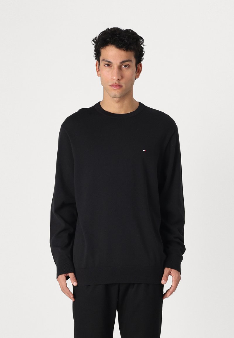 Maglione nero a girocollo realizzato in morbido tessuto, con maniche lunghe e una piccola accentuazione del logo sul lato sinistro del petto. Design dritto.