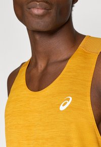 Κίτρινο αθλητικό αμάνικο μπλουζάκι με υφή, με λευκό λογότυπο στο στήθος και φαρδιά λαιμόκοψη για άνεση.