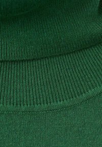 Material tricotat verde cu dungi, cu o textură groasă, având o manșetă superioară puțin mai lejeră și o secțiune inferioară mai strânsă, cu detalii de cusături vizibile.