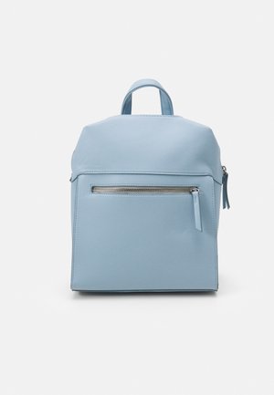 Sac à dos bleu clair avec une poignée supérieure, une poche frontale zippée et un design minimaliste, présenté sur un fond blanc uni.