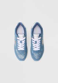 Μπλε τζιν αθλητικά παπούτσια με λευκά κορδόνια και λεπτομέρειες. Εκλεπτυσμένο ανοιχτό μπλε σχέδιο στο πάνω μέρος. Χρυσή μεταλλική λεπτομέρεια στο πλάι.