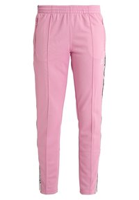 Rosa Sporthose mit schlanker Passform, elastischem Bund, Reißverschlusstaschen und kontrastierenden schwarzen Seitenstreifen. Glatte Stoffstruktur.