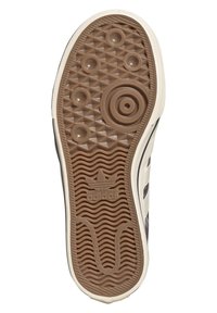 Hnědá guma podrážky boty s texturovanými vzory, včetně kruhových a zigzagových designů, a s vyraženým detailem loga. Horizontální bílý pruh jako akcent.