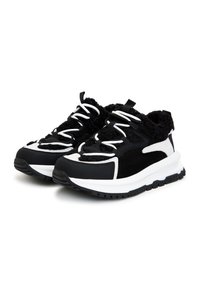 Sneaker in bianco e nero con tomaia strutturata, pannelli a contrasto, lacci rotondi e suola ammortizzata. Caratterizzato da un collo aderente e accogliente.