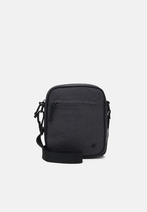 Bolso bandolera de tela negra con textura suave, forma rectangular, bolsillo delantero con cremallera y una correa ajustable. Detalles de diseño minimalista.