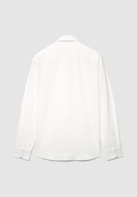 Chemise blanche à manches longues en tissu texturé, avec un col classique, des poignets à boutons et un ourlet arrondi, vue de dos.