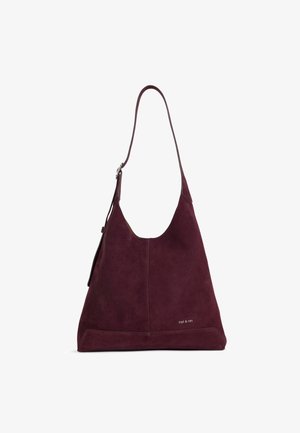 Sac à épaule en daim violet foncé avec une seule bandoulière et un logo "nat & nin" subtil près du coin inférieur droit.