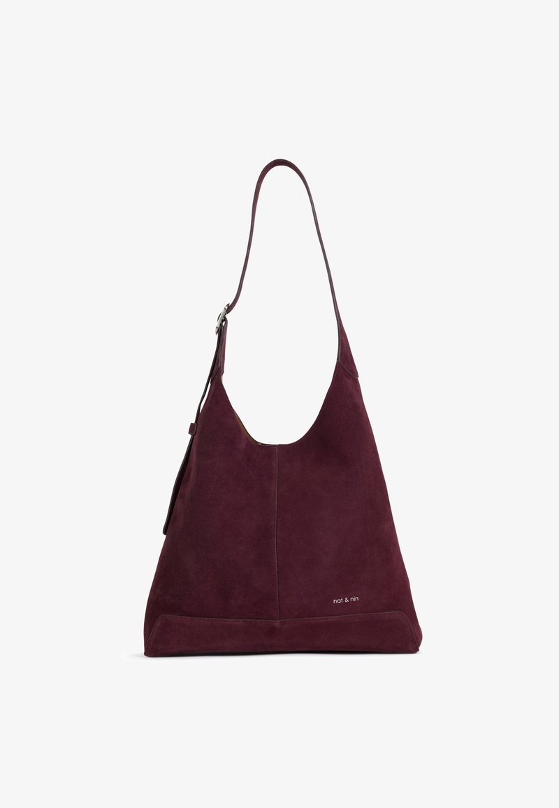 Sac à épaule en daim violet foncé avec une seule bandoulière et un logo "nat & nin" subtil près du coin inférieur droit.