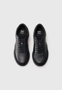 Μαύρα δερμάτινα αθλητικά παπούτσια με υφή, διαθέτουν μαύρες κορδόνες, μαξιλαρωμένα πέλματα και επώνυμες εσωτερικές σόλες. Στρογγυλή σχεδίαση μύτης.