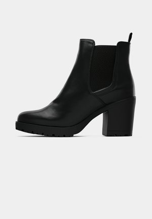 Black leather ankle boot with block heel, elastic side panels, pull tab, and textured sole on a white background.