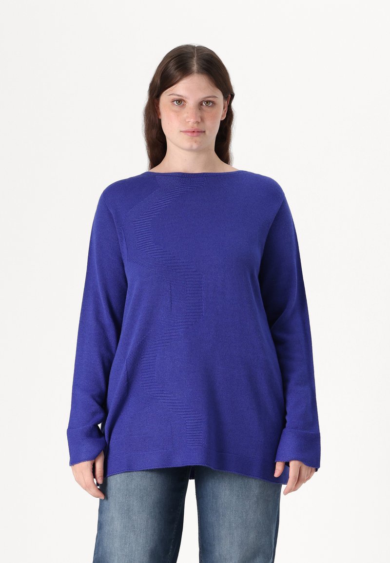 Pulover vibrant albastru, cu guler rotund și mâneci lungi, având un model texturat și o croială lejeră. Asortat cu blugi din denim.
