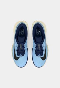 Ανοιχτό μπλε αθλητικά παπούτσια με υφή στο πάνω μέρος, ναυτικές λεπτομέρειες, μαύρο λογότυπο swoosh και κρεμ χρώματος σόλα. Σχέδιο με κορδόνια, αεριζόμενη κατασκευή.