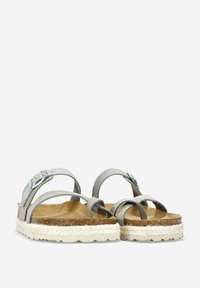 Sandalias de ante gris con correas entrelazadas y hebilla plateada, que cuentan con una plantilla de corcho natural y suela de yute trenzado. Detalle en la parte inferior de goma.