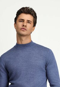 Niebieski sweter wykonany na drutach z wysokim kołnierzem i długimi rękawami. Gładka struktura i dopasowany fason nadają mu elegancki wygląd.