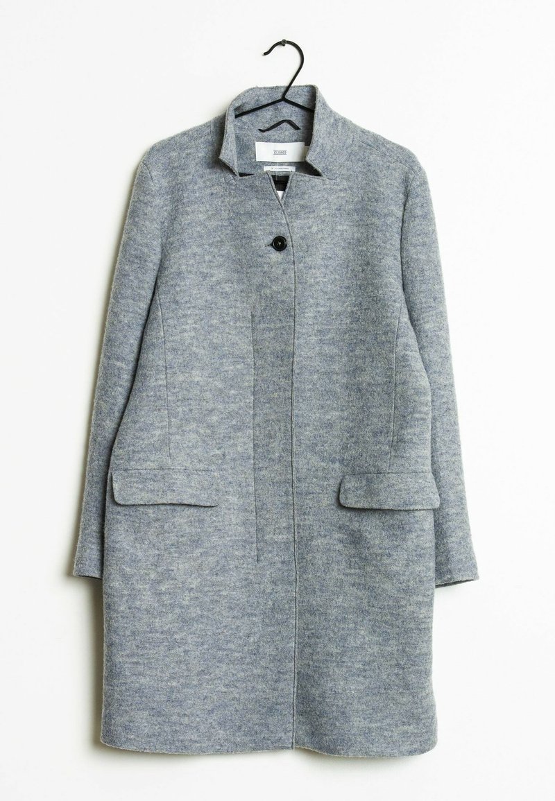 Lys grå uldblanding lang frakke med en enkelt sort knap, to forlommer med klap og en lille ståkrave, hængende på en sort bøjle.