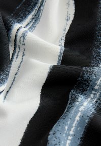 Elastyczna tkanina w czarno-biało-niebieskie wzory o gładkiej fakturze, z abstrakcyjnymi paskami i delikatnym połyskiem.