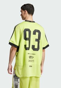 Neon geltonas tinklinis džersis su juodu numeriu 93, trumpomis rankovėmis ir juodomis detalėmis. Ant nugaros yra logotipai ir tekstas.