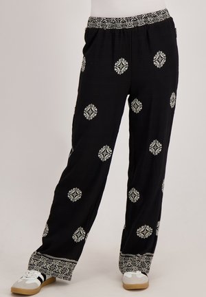 Zwarte, losvallende broek met witte decoratieve patronen, voorzien van een elastische tailleband en textuurstof, met gedetailleerde zoomaccenten.