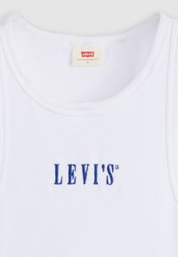 Baltas, raukšlėtas marškinėlis su apvaliu iškirpimu ir mėlynai siuvinėtu "LEVI'S" logotipu priekyje. Etiketėje parašyta "Levi's San Francisco, CAL."