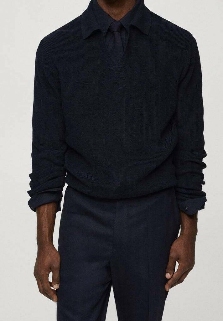 Maglione blu navy a maglia con scollo a V, maniche lunghe e design con colletto. La texture è a costine, abbinato a pantaloni scuri coordinati.