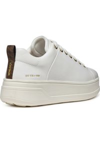 Sneaker bianca in pelle con suola spessa, caratterizzata da occhielli dorati, un accento in pelle marrone testurizzata sul tallone e dettagli di cucitura liscia.