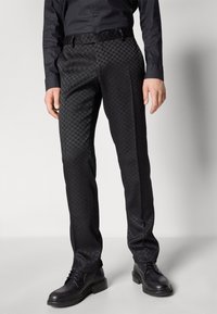 Černé kalhoty s texturovaným vzorem houndstooth, s plochým předním designem a slim fit střihem, doplněné černými šněrovacími botami.
