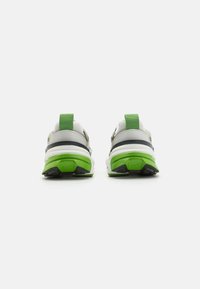 Zapatillas deportivas con parte superior blanca, acentos verdes y un acabado texturizado. Presentan una raya negra y una lengüeta de talón acolchada para mayor soporte.