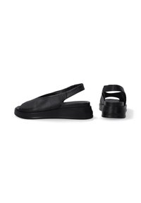 Schwarze Leder-Slingback-Schuhe mit abgerundetem Zehenbereich, flachem Keilsohle und einer glatten Textur. Das Design verfügt über eine offene Rückseite und ausgeschnittene Akzente.