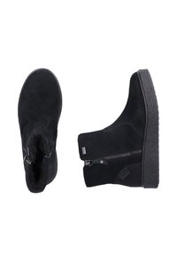 Bottines en suede noir avec une semelle en caoutchouc texturée, des zips sur les côtés et un design épuré. Dotées de coutures lisses et sans logos visibles.