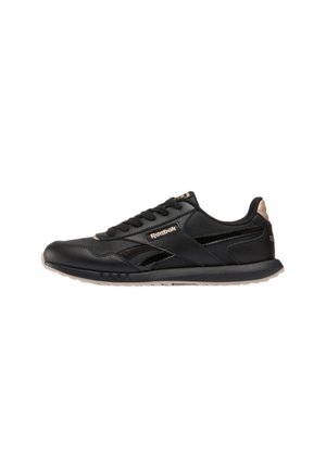 Zwarte Reebok lage sneaker met vetersluiting, subtiele beige accenten en rubberen zool, van opzij getoond op een witte achtergrond.