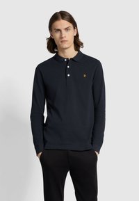 Lange mouw polo shirt in navyblauwe katoen, met een klassieke kraag, drie knopen en een geborduurd oranje logo op de borst.