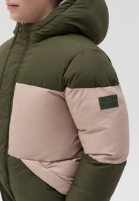 Giubbotto imbottito in verde oliva e rosa chiaro, con cappuccio, tessuto strutturato e una toppa con la scritta "ATLETICA" sulla manica.