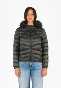 Giacca puffer verde scuro con zip frontale, polsini a costine e colletto in pelliccia verde morbida. Il tessuto ha una superficie liscia e lucida.