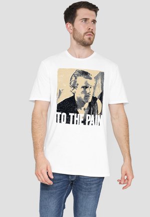 White cotton t-shirt featuring a graphic print of a man's portrait and the text "TO THE PAIN" in bold black letters. Short sleeves.