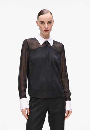 Black blouse with sheer long sleeves, a white collar, and a tie detail at the neck. Features a smooth texture and tailored fit.