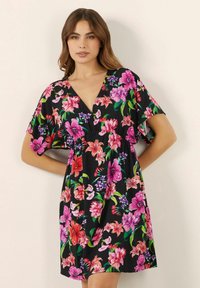 Abito floreale con scollo a V, maniche corte, fondo nero e vivaci motivi floreali rosa, viola e verdi.